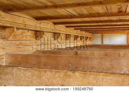 Dachau Concentration Camp Germany - July 30 2016: Inside sleeping quarters with wooden bunk beds from barrack room showing terrible prisoners living conditions from extermination camp.