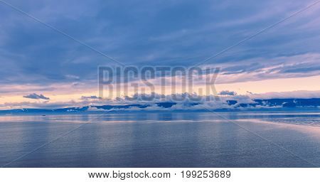 Sunset in the calmness on the lake and slowly floating boat