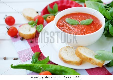 Cold summer tomato dish. Gaspacho soup with toast cherry tomatoes pepper basil herbs.