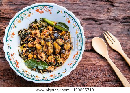 Hot and spicy stir fried eel in bowl on an old wooden background
