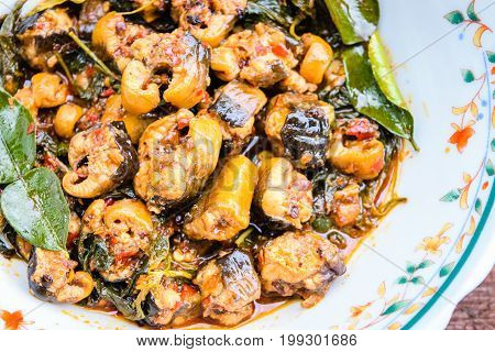 Hot and spicy stir fried eel in bowl on an old wooden background