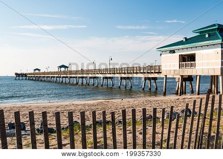 HAMPTON, VIRGINIA - JULY 9, 2017:  The Buckroe Beach fishing pier, located on the site of a former plantation.  The area is now a popular tourist attraction for the beach, fishing and public park.