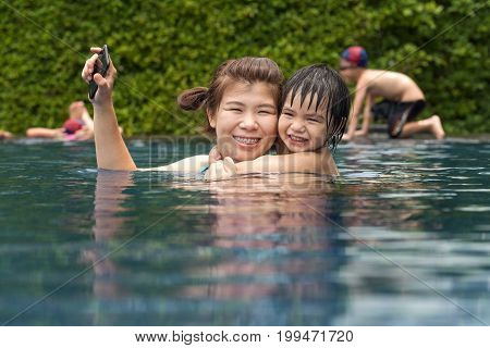 mother and asian boy swimming in pool
