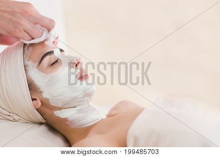 Facial mask removing at beauty salon. Spa beauty organic facial mask.