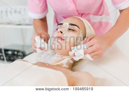 Facial mask removing at beauty salon. Spa beauty organic facial mask.