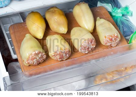 Frozen stuffed pepper on a cutting board in the freezer