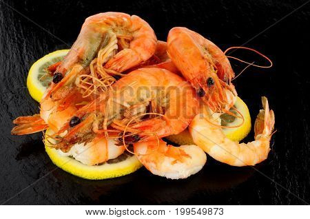 Group of whole fried king tiger prawns on a slate stone background