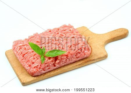 Raw minced pork on the chopping board pork meat on white background decorated with basil leaf