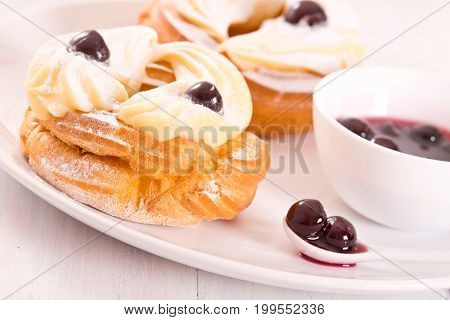 Zeppole with pastry cream and cherry syrup.