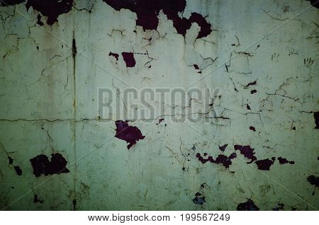 Peeling plaster on the wall in dark tones like in horror movies (as an abstract grungy background)