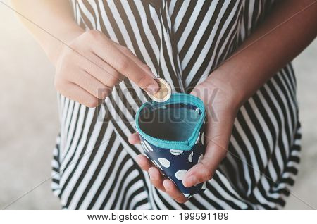 Hands holding bank bills and small money pouch