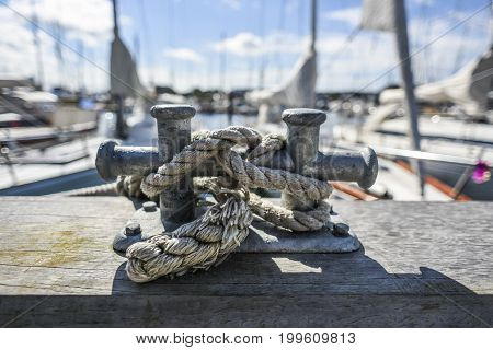 Old harbor mooring in the background of the summer marina on a sunny day.