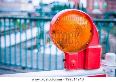 Orange construction warning street barrier light on barricade. Road construction on the streets of European cities. Germany. Hamburg.