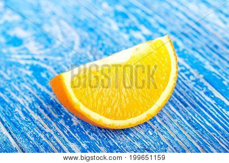 slice of ripe juicy orange on a blue background