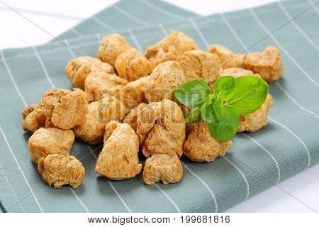 pile of soy meat cubes on grey place mat - close up