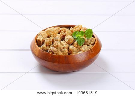bowl of soy meat cubes on white wooden background