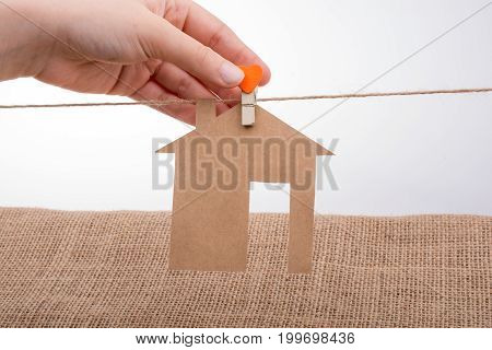 Hand Holding A Paper House On Canvas