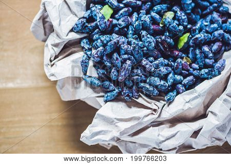 Fresh Honeysuckle Blue Berry Fruits With Leaf On A Wooden Background