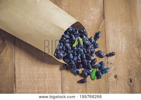 Fresh Honeysuckle Blue Berry Fruits With Leaf On A Wooden Background