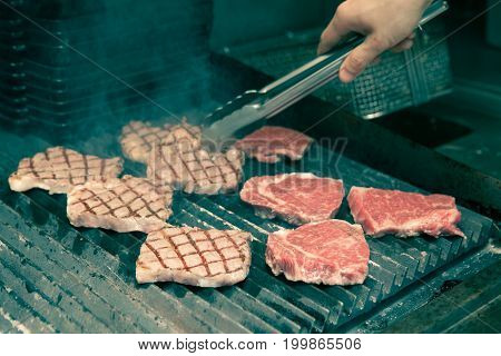 Chef In Hotel Or Restaurant Kitchen Grilling Pork For Luxury Dinner Party With Vintage Color Style.