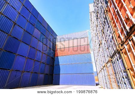 Forklift truck lifting cargo container in shipping yard or dock yard against sunrise sky with cargo container stack in background for transportation importexport and logistic industrial concept