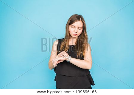 Time is over. Attractive brunette woman pointing to her hand reminding about time.