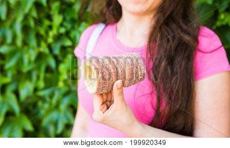 Close-up of young female tourist with traditional czech dessert trdelnik in Prague. Czech Republic. Outdoor.