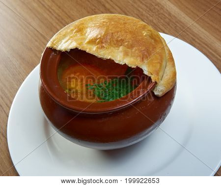 Russian vegetable soup in ceramic pot. close up cooked meal
