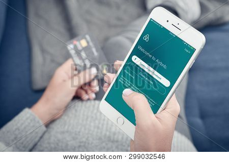 Kyiv, Ukraine - January 24, 2018: Woman Using Airbnb App On Apple Iphone 8 Plus At Home. Airbnb Is A