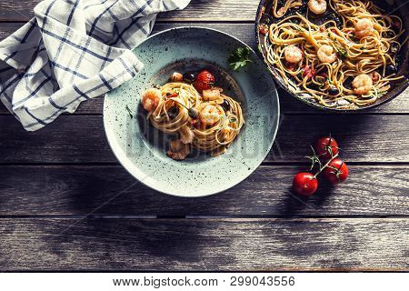 Pasta Spaghetti On Plate And Pan With Shrimp Tomato Sauce Toatoes And Herbs. Italian Or Mediterranea