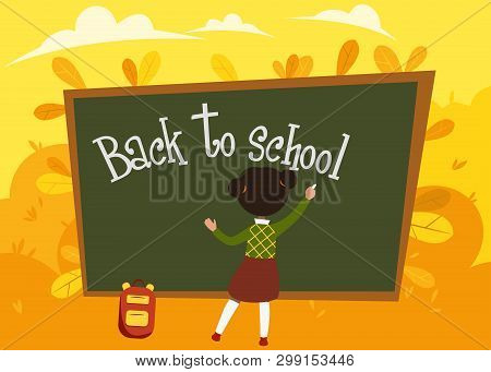Girl Schoolgirl Writes On The School Board Against The Background Of Autumn Foliage