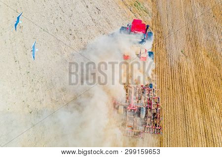 Red Tractor Cutivating Soil On Farmland. Aerial Landscape. Farming Concept