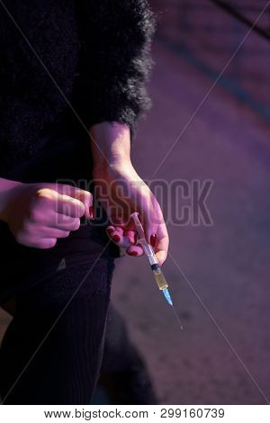 Syringe Close Up In Hands Of A Drug Addiction Redhead Caucasian White Young Woman Wearing Black Swea