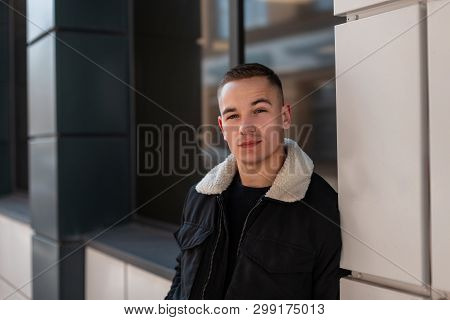 Handsome Young Man With A Stylish Hairstyle In A Fashionable Black Jacket In A T-shirt Posing Standi