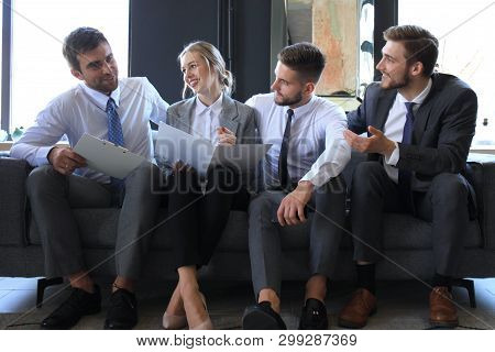 Group Of Four Business People Sitting On Sofa. They Couldnt Be Happier About Working Together.