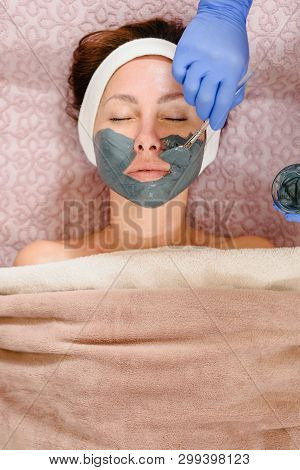 Closeup Of Cosmetologist Applaying Anti Aging Mask On Female Face In Beauty Salon
