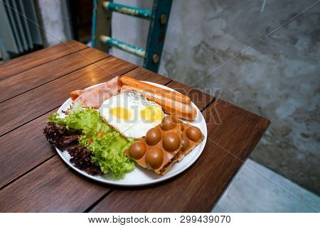 Big Hot Breakfast Wiht Fried Eggs, Sausages, Ham, Waffle And Salad