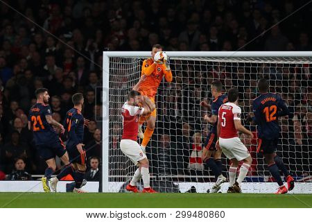 LONDON, ENGLAND - MAY 02 2019: Neto of Valencia drops a catch under a challenge from Shkodran Mustafi of Arsenal during the Europa League semi final leg one match between Arsenal and Valencia.