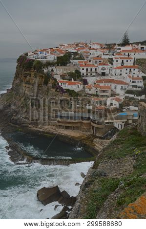 Views Of The Houses Perfectly Located On A Cliff And With A Natural Pool On Their Background In Cola