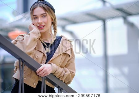 Portrait of blonde girl with flyaway hair in the street background 