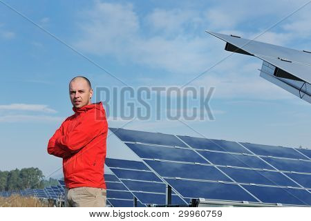 Engenheiro masculino no local de trabalho, a fábrica de painéis solares industy no fundo