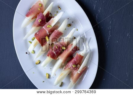 Still life of jamon serrano with yellow melon