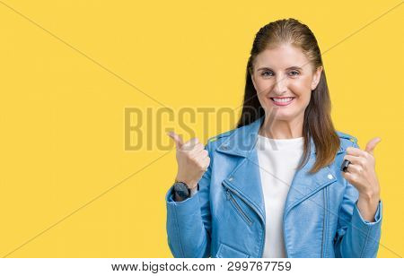 Beautiful middle age mature woman wearing fashion leather jacket over isolated background success sign doing positive gesture with hand, thumbs up smiling and happy. Looking at the camera