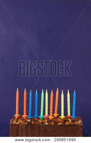Happy Birthday Brownie Cake With Peanuts, Salted Caramel And Colorful Unlighted Candles On The Viole