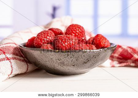 Lot Of Whole Fresh Red Raspberry On Grey Ceramic Plate With A Tea Towel With Blue Window In A White 