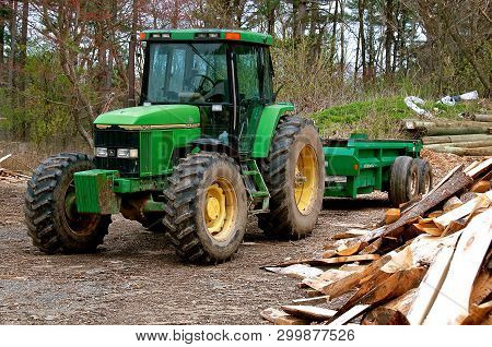 Rowley, Massachusetts, April 28, 2019: The  7400 John Deere Tractor  Pulling A Trailer At A Sawmill 