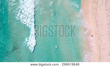 Unique straight down aerial view of people swimming at a tropical beach in Cozumel, Mexico.
