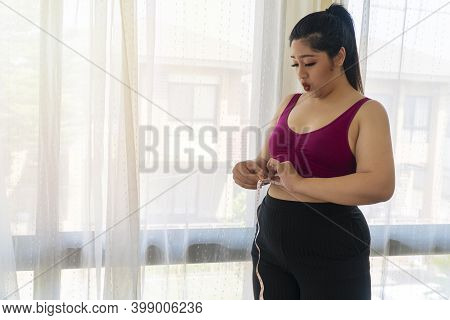 Obesity Unhealthy Concept. Overweight Woman Wear Sport Bar With Measure Tape On Body Pinches Fat On 