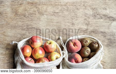 Organic Fruits In Reusable Eco Friendly Natural Bag On The White Wooden Background