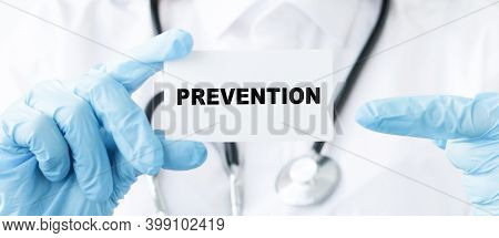 Doctor Holding A Card With Text Prevention, Close-up Of Blue-gloved Hands Holding A Card. Medical Co